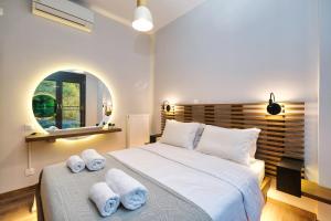 a bedroom with a large white bed with towels on it at Strefi Hill Suites in Athens