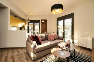 een woonkamer met een bank en twee tafels bij Strefi Hill Suites in Athene