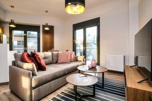 sala de estar con sofá y 2 mesas en Strefi Hill Suites en Atenas