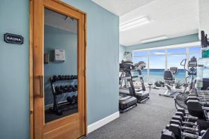 a gym with treadmills and exercise equipment and the ocean at Emerald Isle by Panhandle Getaways in Panama City Beach