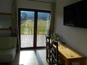 a dining room with a table and a sliding glass door at Casa Rudi & Ella in Sălişte