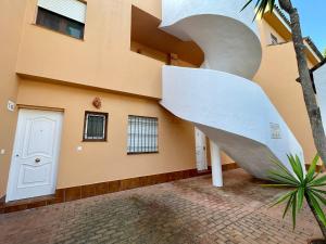 a building with a sculpture in front of it at Apartamento Caracas in Chiclana de la Frontera