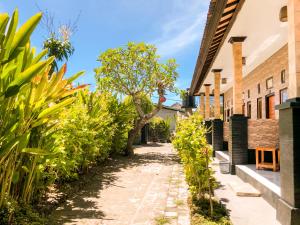 an alley in the courtyard of a house with plants at Double-G Guest House in Nusa Penida