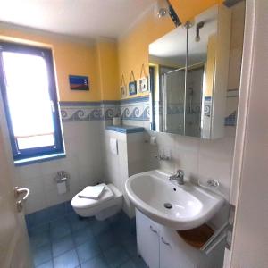 a white bathroom with a sink and a toilet at Carpe Diem in Zingst