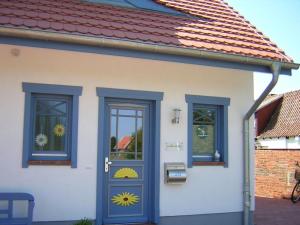 a small house with a blue door and two windows at Carpe Diem in Zingst