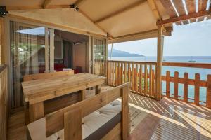 a porch with a bench and a view of the ocean at Camping Village Scaglieri in Portoferraio