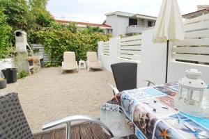 a patio with a table and chairs and an umbrella at Apartments Rozanda in Baška
