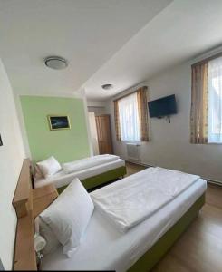 Zimmer mit 2 Betten und einem TV. in der Unterkunft Waldrestaurant VIDA in Kapfenberg