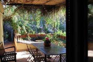 una mesa con un jarrón de flores en un patio en Inn The Garden, en Catania