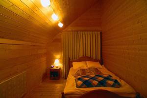 1 dormitorio con 1 cama en una cabaña de madera en HARUNA CABIN 森の中のログハウス 、広々ウッドデッキでBBQ、公園散策、北軽井沢観光, en Azumaiokozan