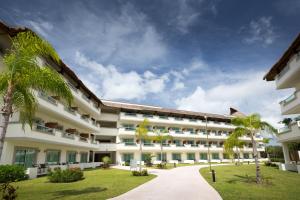 una vista exterior de un gran edificio blanco con palmeras en BlueBay Grand Esmeralda-All Inclusive, en Playa del Carmen