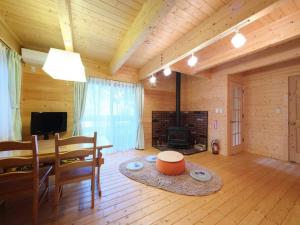 a living room with a table and a fireplace at HARUNA CABIN 森の中のログハウス 、広々ウッドデッキでBBQ、公園散策、北軽井沢観光 in Azumaiokozan