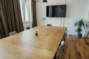 una sala de conferencias con una gran mesa de madera con sillas en Schlafladen Hildesheim Hotel & Hostel, en Hildesheim