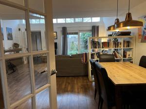 a dining room and living room with a table at Family house next to train and close to Amsterdam and Schiphol in Almere