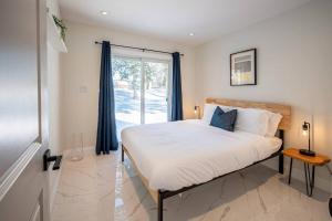 a bedroom with a bed and a large window at Kingsdale Designer Tiny House with Tesla Charger in Kitchener