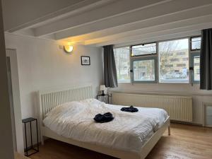 Un dormitorio con una cama con dos guantes negros. en Family house next to train and close to Amsterdam and Schiphol, en Almere