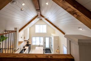 an attic room with a white ceiling with a window at Kingsdale Designer Tiny House with Tesla Charger in Kitchener