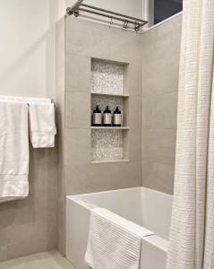 y baño blanco con bañera y toallas. en Close to all! 2-room suite in a 1-family townhouse, en Brooklyn