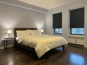 um quarto com uma cama grande e 2 janelas em Close to all! 2-room suite in a 1-family townhouse em Brooklyn