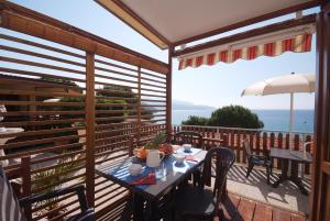 a table on a balcony with a view of the ocean at Camping Village Scaglieri in Portoferraio
