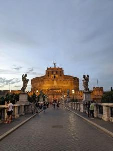 Vatican Vacation Home Interno 2 في روما: مبنى كبير فيه ناس تمشي على جسر