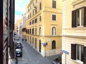 eine Stadtstraße mit Autos, die an der Seite eines Gebäudes geparkt sind in der Unterkunft Vatican Vacation Home Interno 2 in Rom