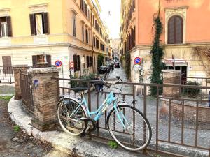 un vélo bleu est garé à côté d'une clôture dans l'établissement Vatican Vacation Home Interno 2, à Rome 12 autres photos