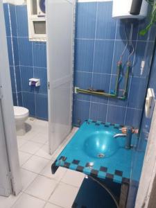 a blue tiled bathroom with a sink and a toilet at Bab alkhair Hostel in Cairo