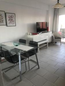 Una sala de estar con una mesa y sillas y un televisor. en Sol y Paz, en Torremolinos 11 fotos más