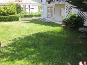 a grass yard with a bench and a house at Habitaciones López Azcona in Noja