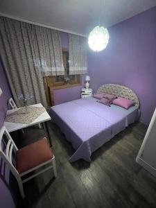 ein lila Schlafzimmer mit einem großen Bett und einem Stuhl in der Unterkunft Salaš Gnijezdo in Bačka Palanka