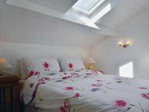 ein Schlafzimmer mit einem Bett mit rosa Blumen drauf in der Unterkunft Little Barn in Gilwern