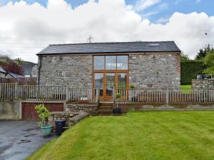 une maison en pierre avec une clôture et une cour dans l'établissement Little Barn, à Gilwern