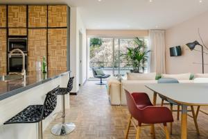 cocina y sala de estar con mesa y sillas en Bloemendaal Hotel Collection Apartments, en Bloemendaal