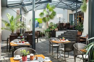 un restaurant avec des tables, des chaises et des plantes dans l'établissement Angel's - das hotel am fruchtmarkt, à Saint-Wendel