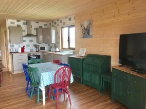 a kitchen with a table and chairs and a television at Lakeside Fishing Lodges in Boston