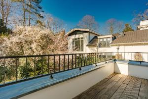 d'un balcon avec une clôture et une maison. dans l'établissement Bloemendaal Hotel Collection Apartments, à Bloemendaal