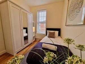 a bedroom with a bed and a large mirror at Spacious Luxury Serviced Apartment next to City Centre with Free Parking - Contractors & Relocators in Coventry