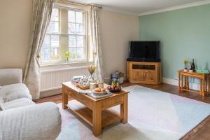 ein Wohnzimmer mit einem Couchtisch und einem TV in der Unterkunft Finest Retreats - Bryn Seion in Llanrwst