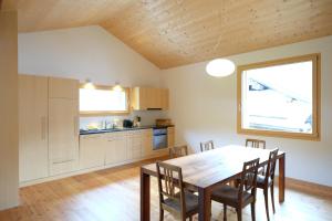 eine Küche und ein Esszimmer mit einem Holztisch und Stühlen in der Unterkunft La Grobla - Die ruhige & heimelige Ferienwohnung in Zillis