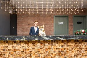 Een man en een hond zitten achter een toonbank. bij Skio in Goedaoeri