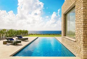 a swimming pool with a view of the ocean at Cap St Georges Villas in Peyia