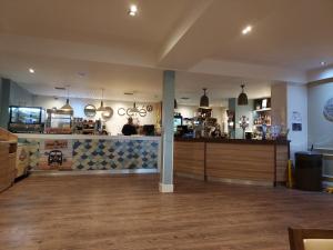un restaurante con barra en una habitación con suelo de madera en Hoburne Bashley Self-Catering Holiday Home en New Milton