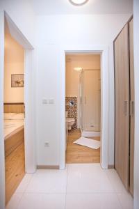 biała łazienka z toaletą i umywalką w obiekcie Apartments Maslina III w mieście Nijvice +26 zdjęć