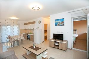 Apartments Maslina III في نجيفيش: غرفة معيشة مع مطبخ وغرفة طعام