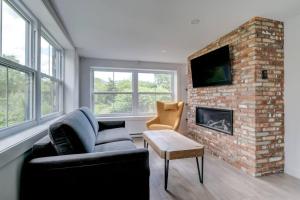 a living room with a couch and a brick fireplace at condo 3 chambres vue sur la montagne 837-202 in Bromont