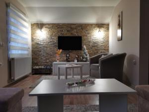 a living room with a table and a tv at Apartman Pogled Arilje in Arilje