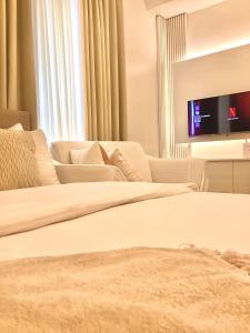 sala de estar con 2 camas y TV de pantalla plana en AZRA Bacolod at Mesavirre Garden Residences en Bacolod