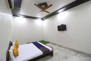 a room with a bed with a ceiling fan and a tv at Hotel Classic in Lucknow