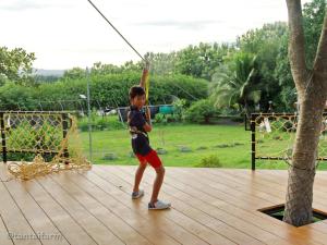 a young boy is swinging on a swing at Tantai Eco Farm Stay At Khao Yai in Ban Sap Noi